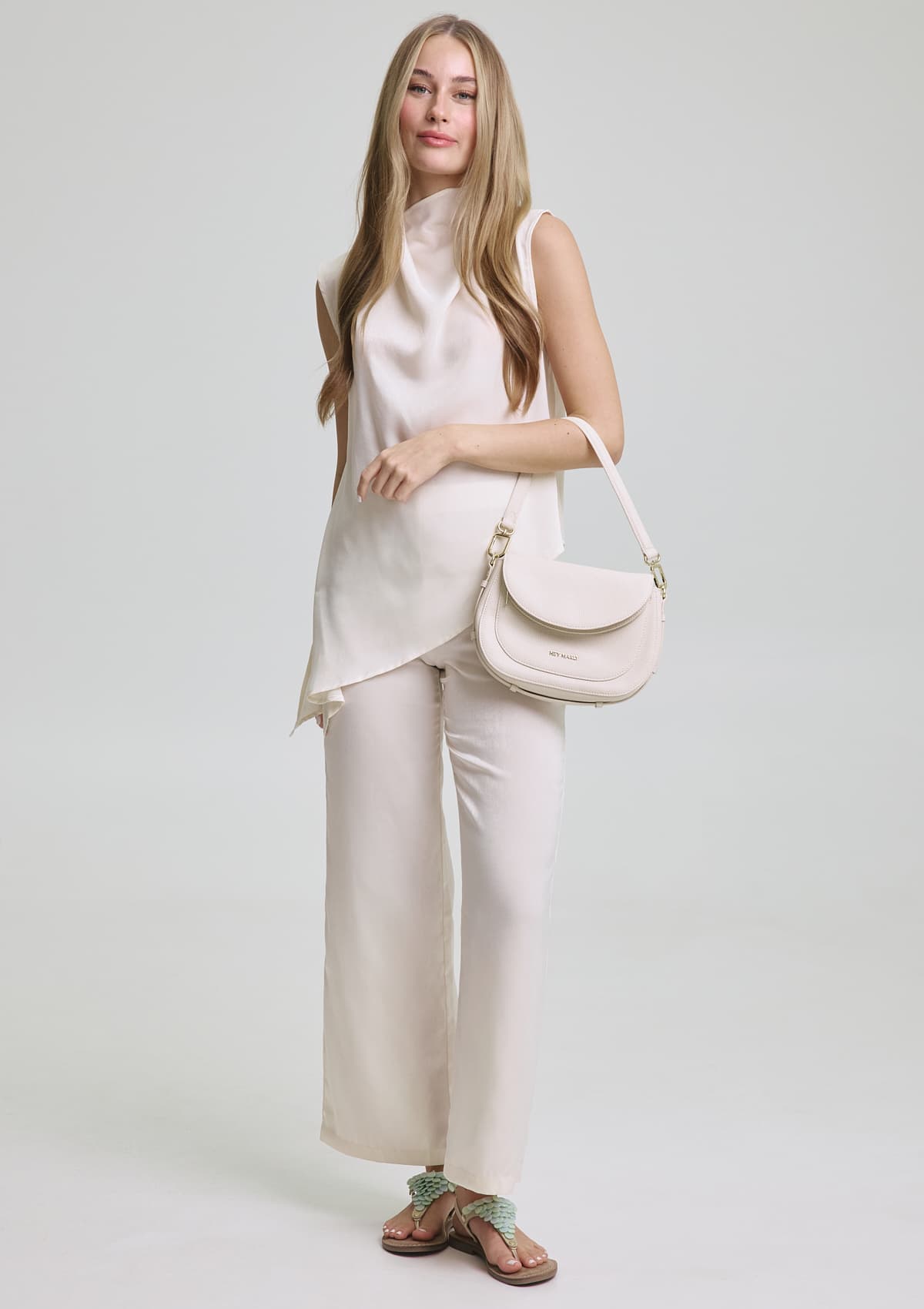 Tragebild mit Model auf neutralem Hintergrund des Produktes Shiny Plate in der Farbe Comfort Crema