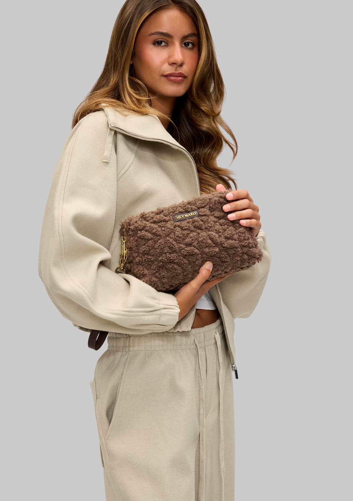 Tragebild mit Model auf neutralem Hintergrund des Produktes Little Buddy Teddy in der Farbe Coffee