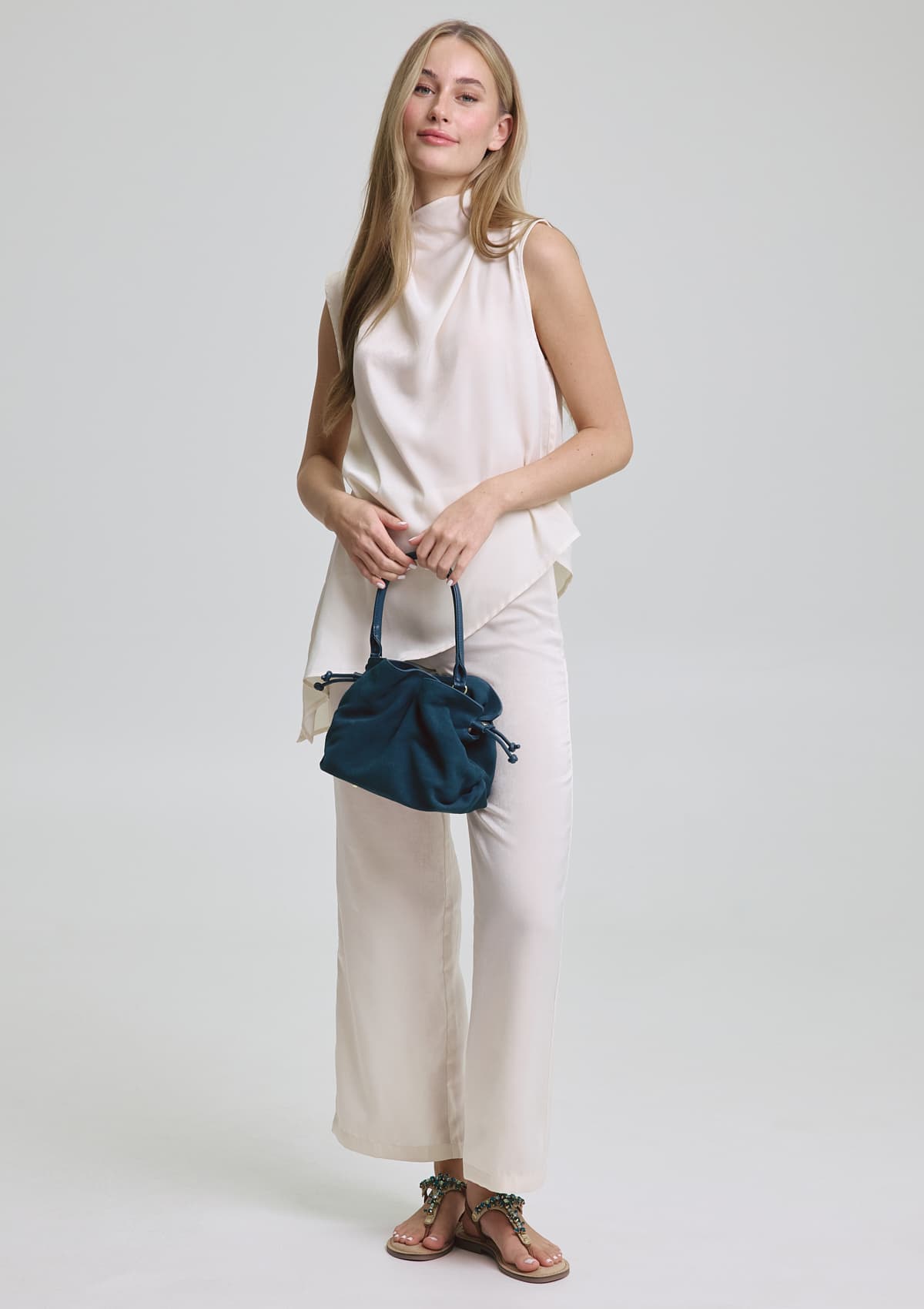 Tragebild mit Model auf neutralem Hintergrund des Produktes Cool Companion Suede S in der Farbe Teal in der Größe S