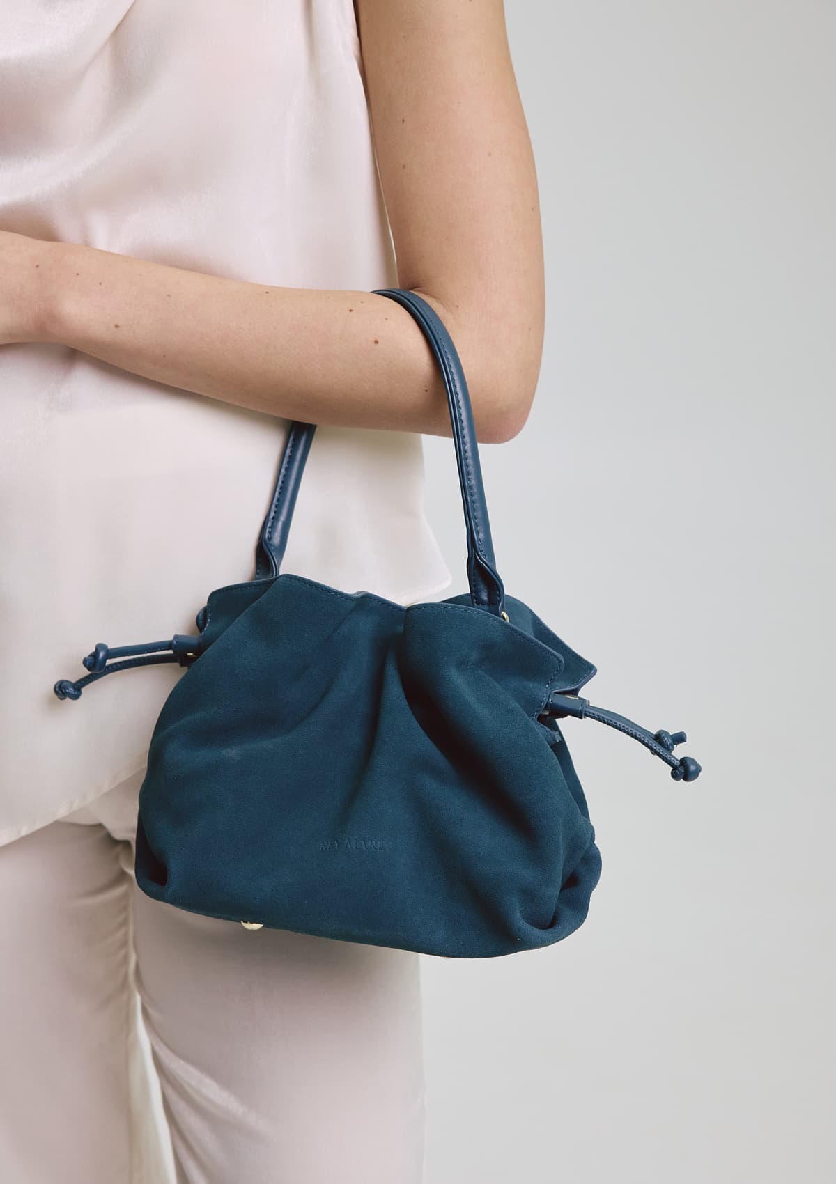 Tragebild mit Model auf neutralem Hintergrund des Produktes Cool Companion Suede S in der Farbe Teal in der Größe S