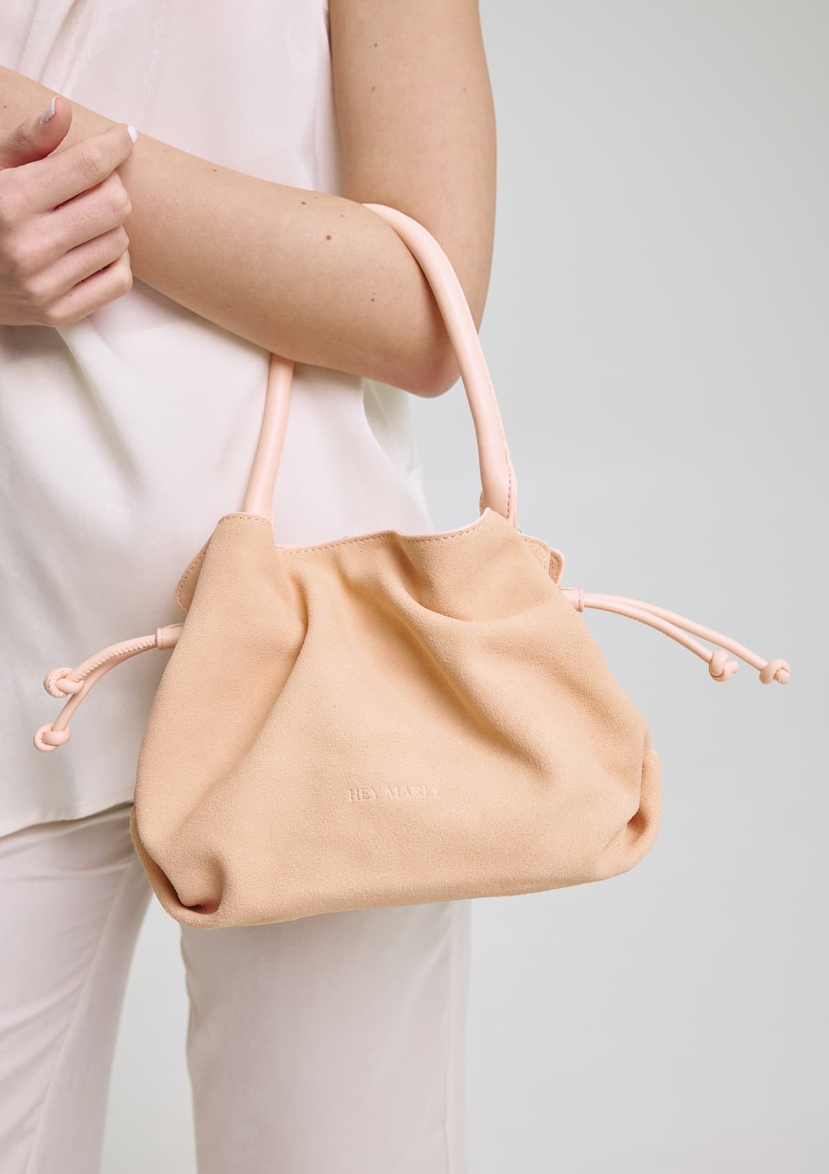 Tragebild mit Model auf neutralem Hintergrund des Produktes Cool Companion Suede S in der Farbe Apricot in der Größe S