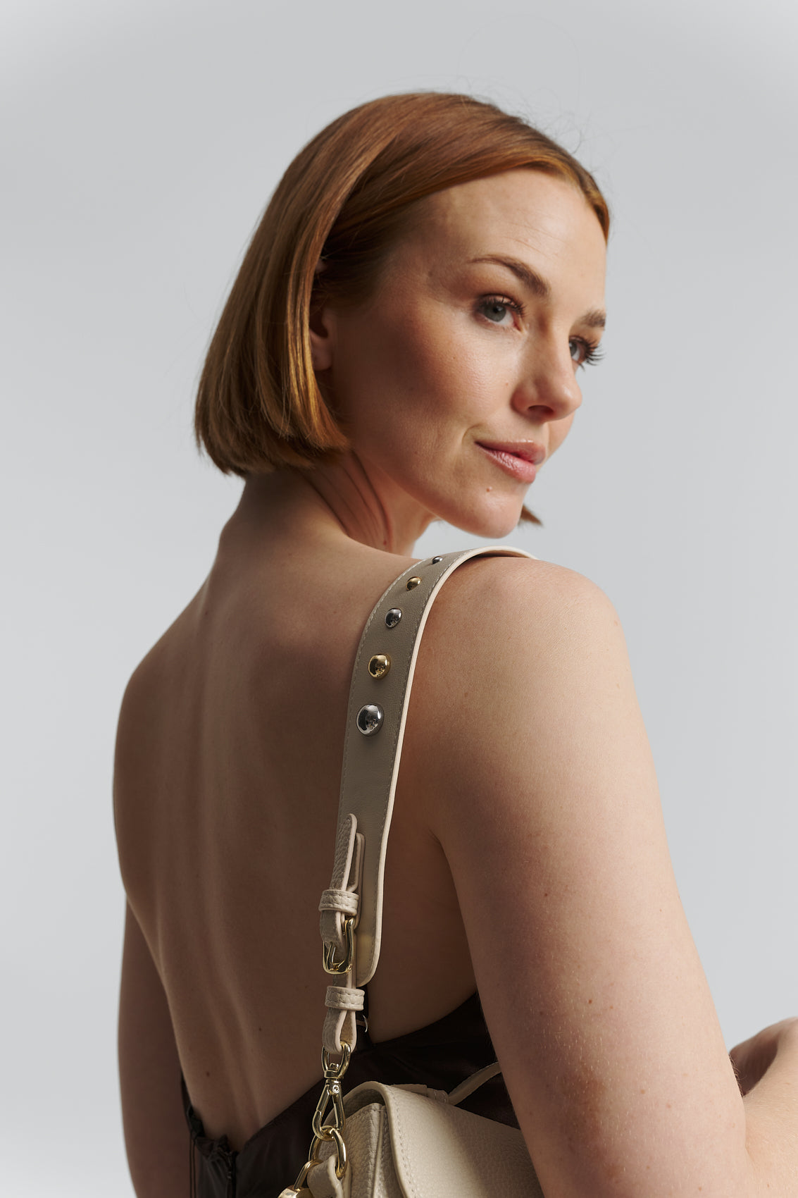 Tragebild mit Model auf neutralem Hintergrund des Produktes Urban Stud Strap in der Farbe Crema