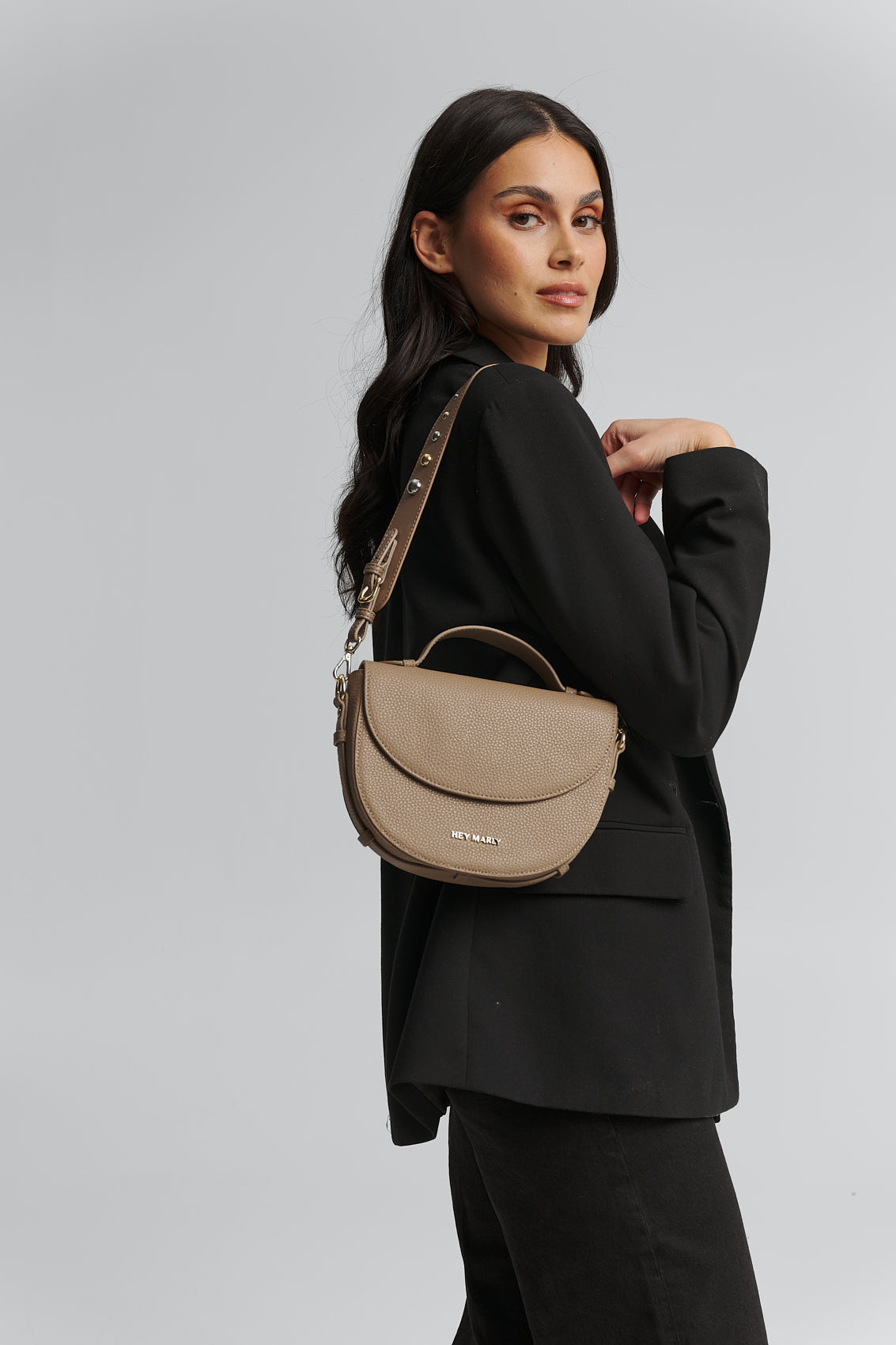 Tragebild mit Model auf neutralem Hintergrund des Produktes Urban Stud Strap in der Farbe Mocha