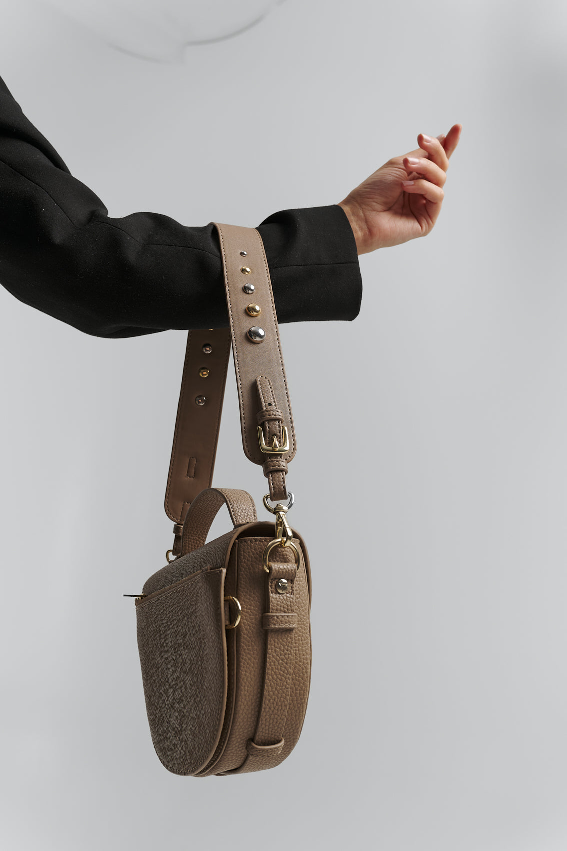 Tragebild mit Model auf neutralem Hintergrund des Produktes Urban Stud Strap in der Farbe Mocha