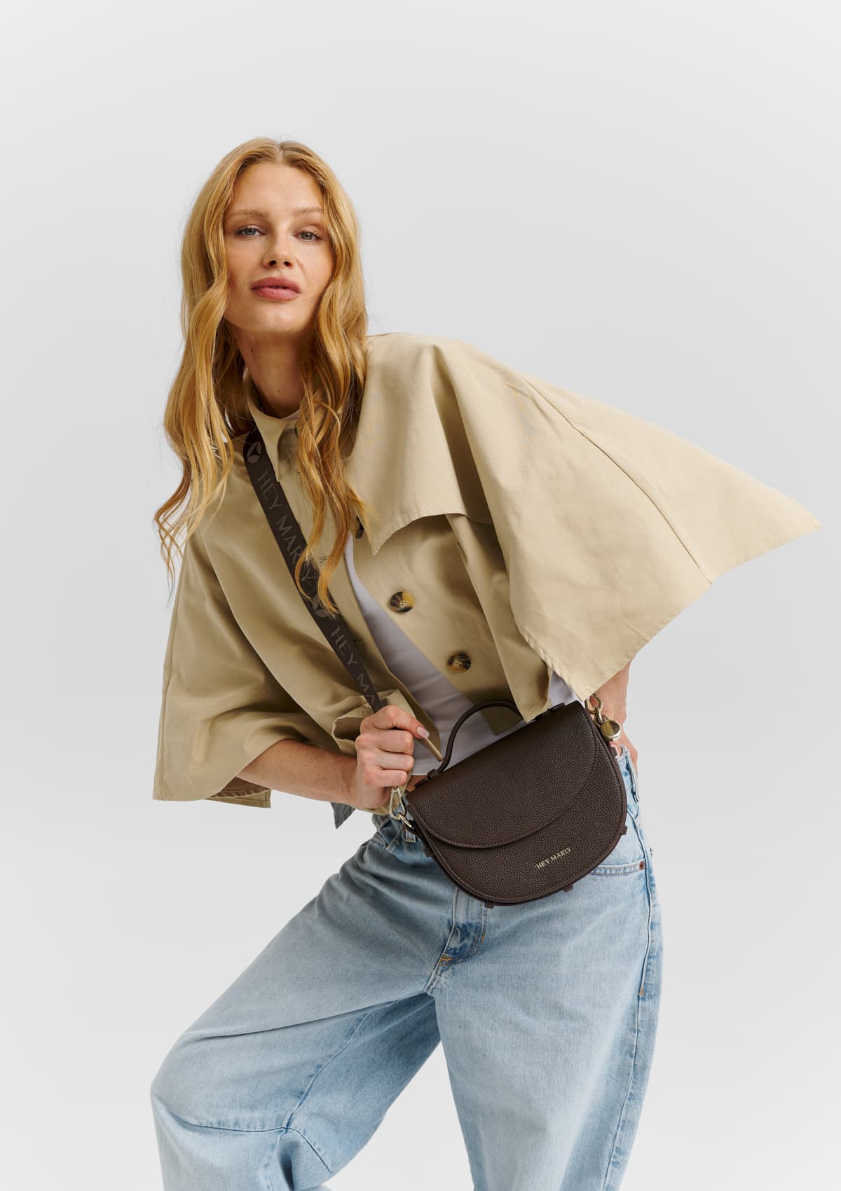 Tragebild mit Model auf neutralem Hintergrund des Produktes Signature Strap in der Farbe Coffee