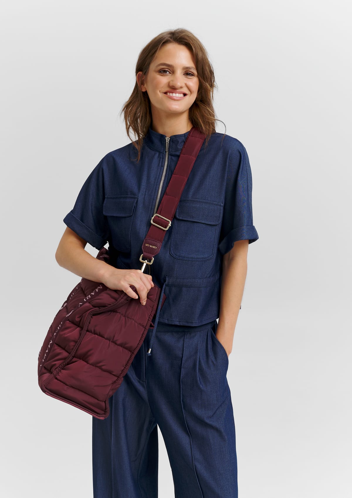Tragebild mit Model auf neutralem Hintergrund des Produktes Puffy Nylon Strap in der Farbe Berry