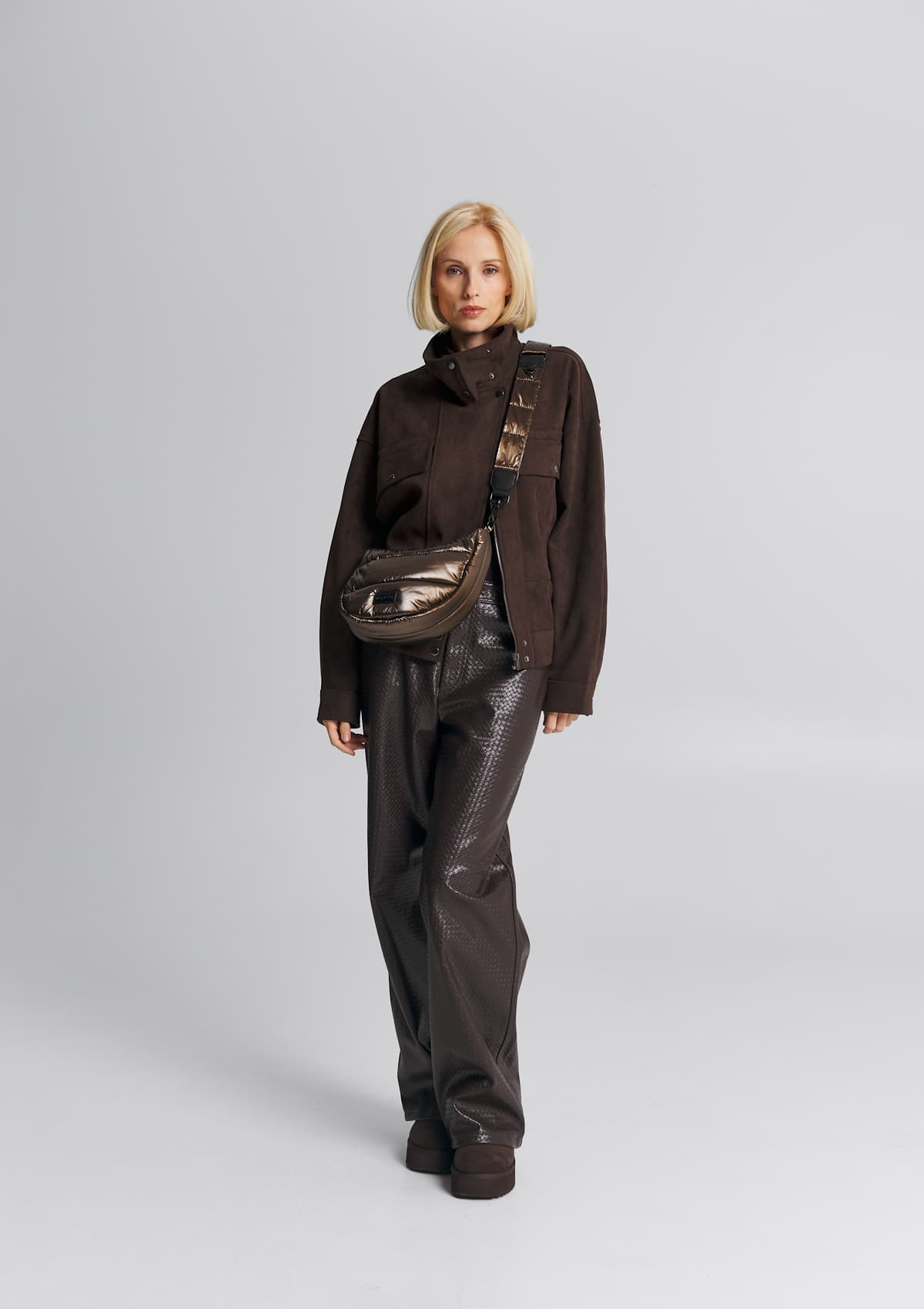 Tragebild mit Model auf neutralem Hintergrund des Produktes Puffy Nylon Strap Blaze in der Farbe Coffee