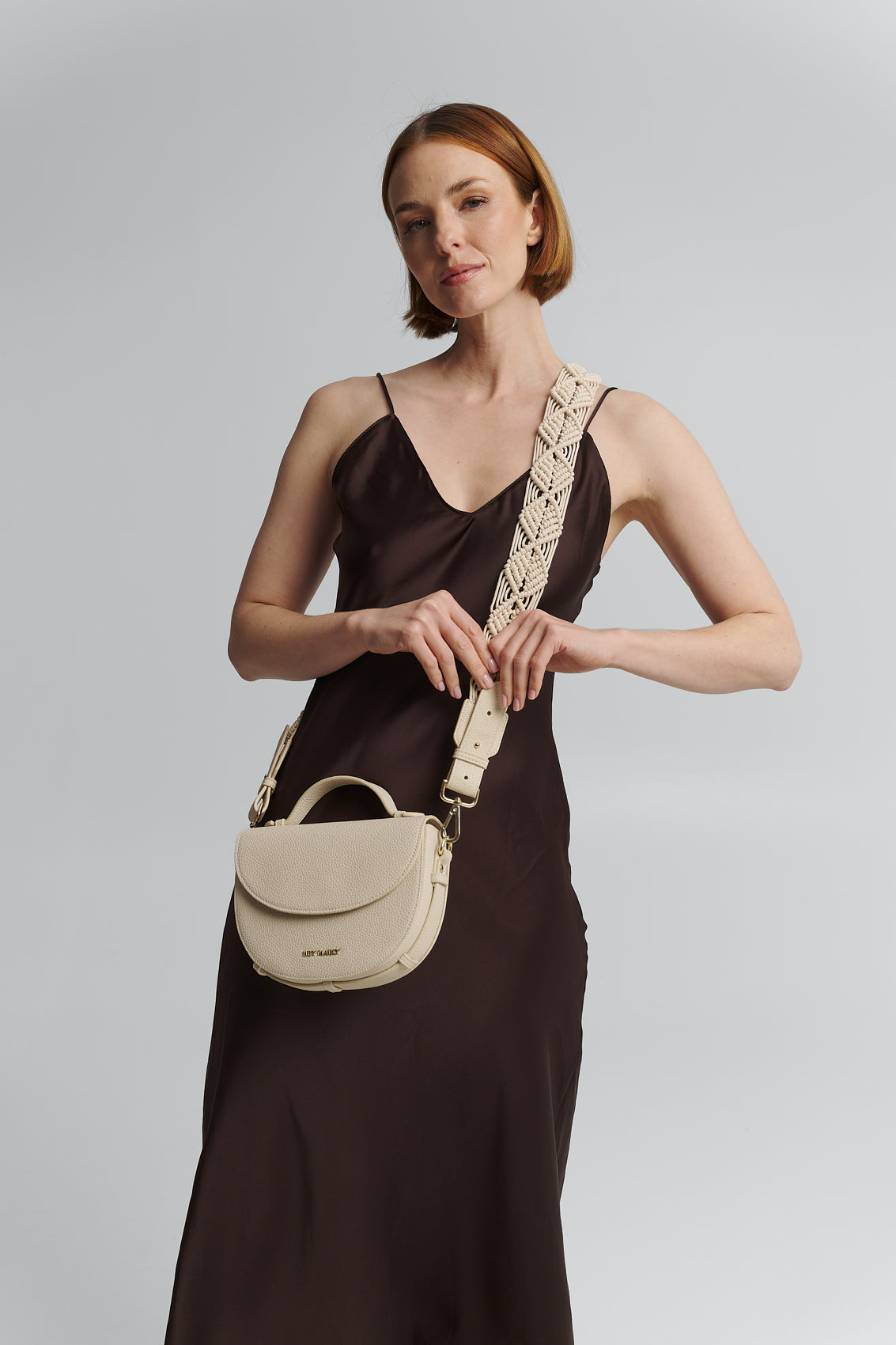 Tragebild mit Model auf neutralem Hintergrund des Produktes Makrame Strap in der Farbe Crema