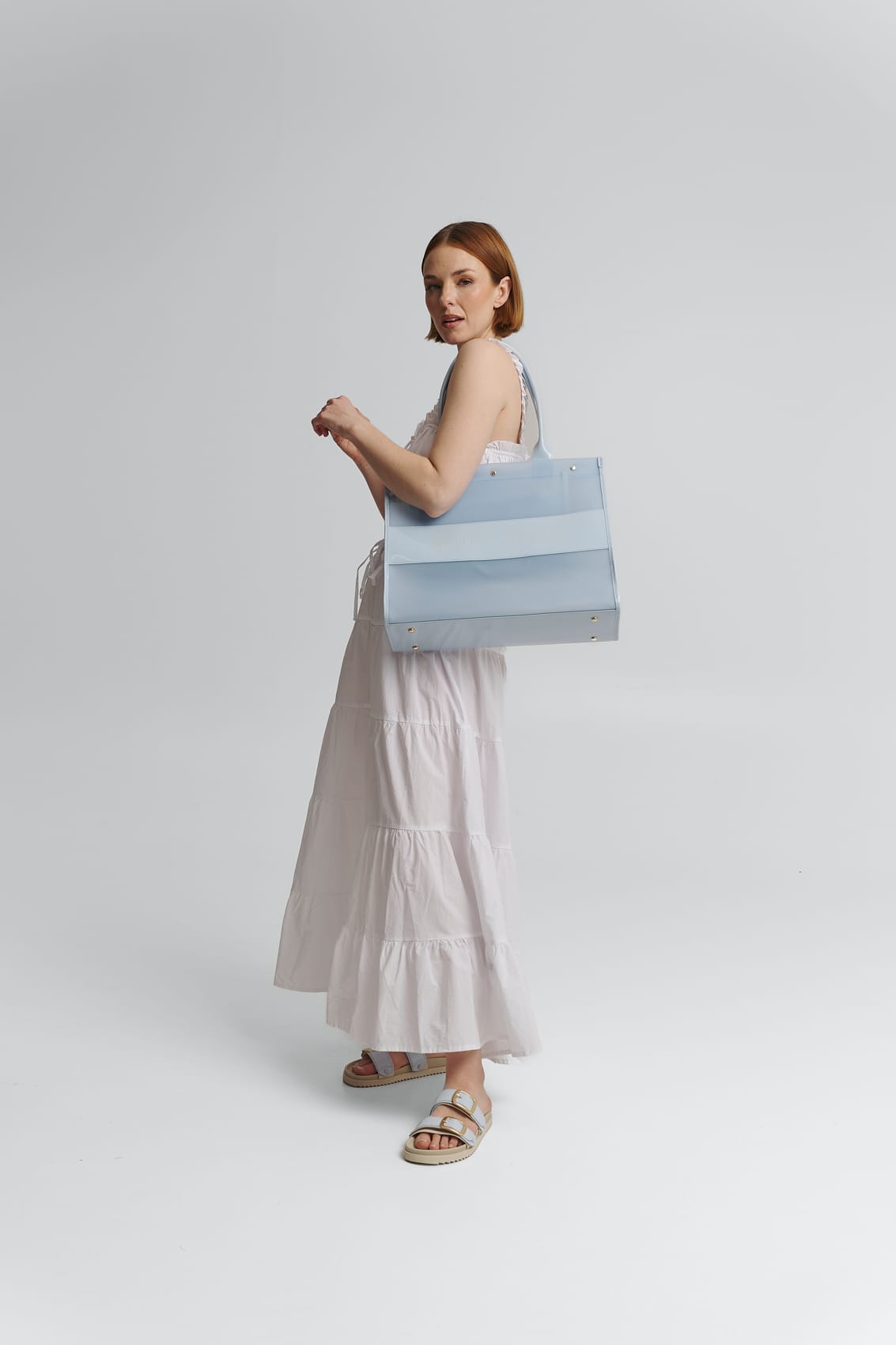 Tragebild mit Model auf neutralem Hintergrund des Produktes Transparent Signature Bag in der Farbe Blue Light