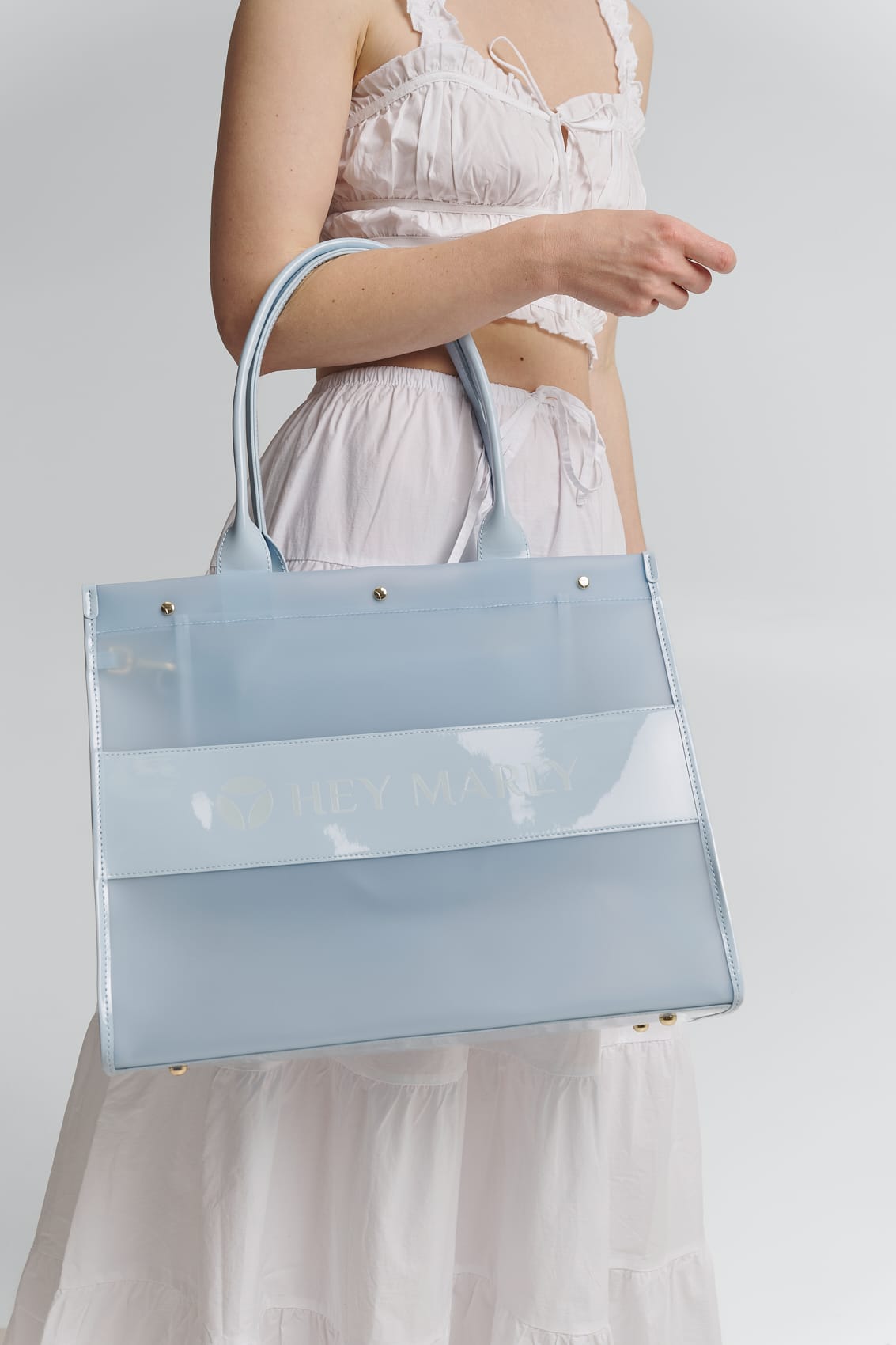 Tragebild mit Model auf neutralem Hintergrund des Produktes Transparent Signature Bag in der Farbe Blue Light