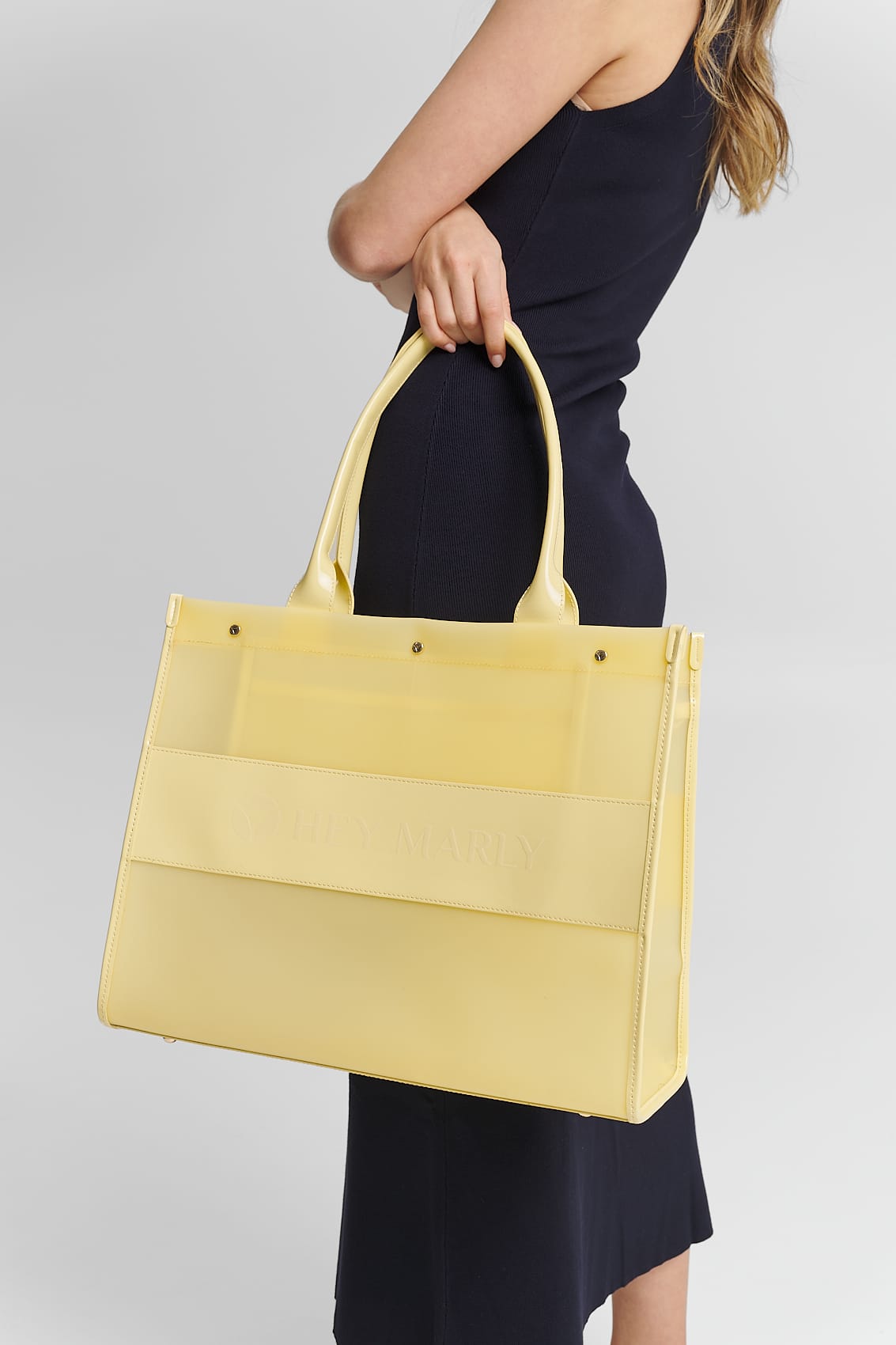 Tragebild mit Model auf neutralem Hintergrund des Produktes Transparent Signature Bag in der Farbe Yellow Light