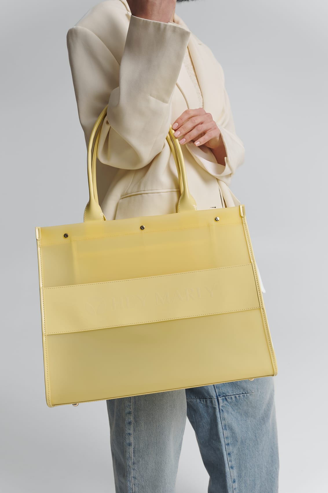 Tragebild mit Model auf neutralem Hintergrund des Produktes Transparent Signature Bag in der Farbe Yellow Light