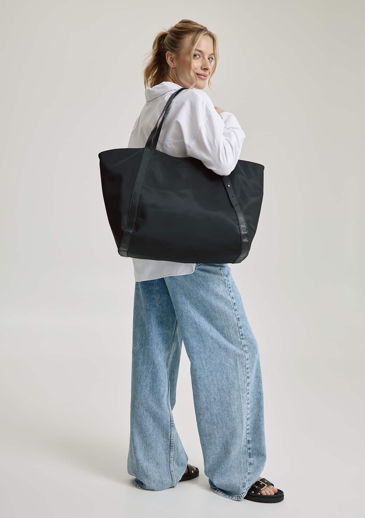 Tragebild mit Model auf neutralem Hintergrund des Produktes Pretty Wonder Nylon L in der Farbe Black in der Größe L