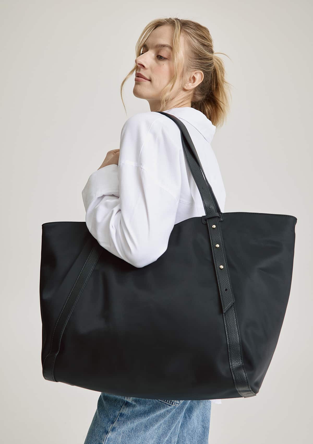 Tragebild mit Model auf neutralem Hintergrund des Produktes Pretty Wonder Nylon L in der Farbe Black in der Größe L