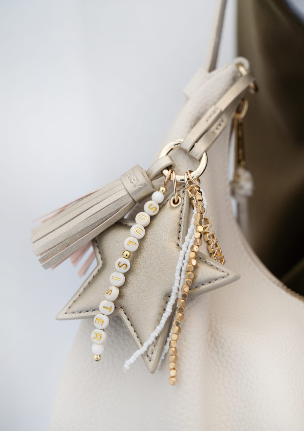 Tragebild mit Model auf neutralem Hintergrund des Produktes Star Tassle Charm in der Farbe Gold