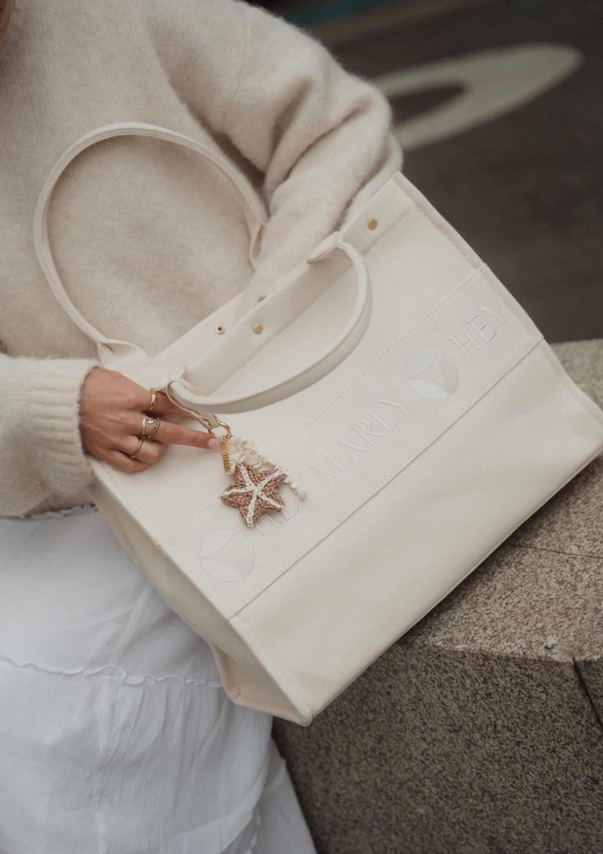 Tragebild mit Model auf neutralem Hintergrund des Produktes Sea Star Charm in der Farbe Sand-Crema