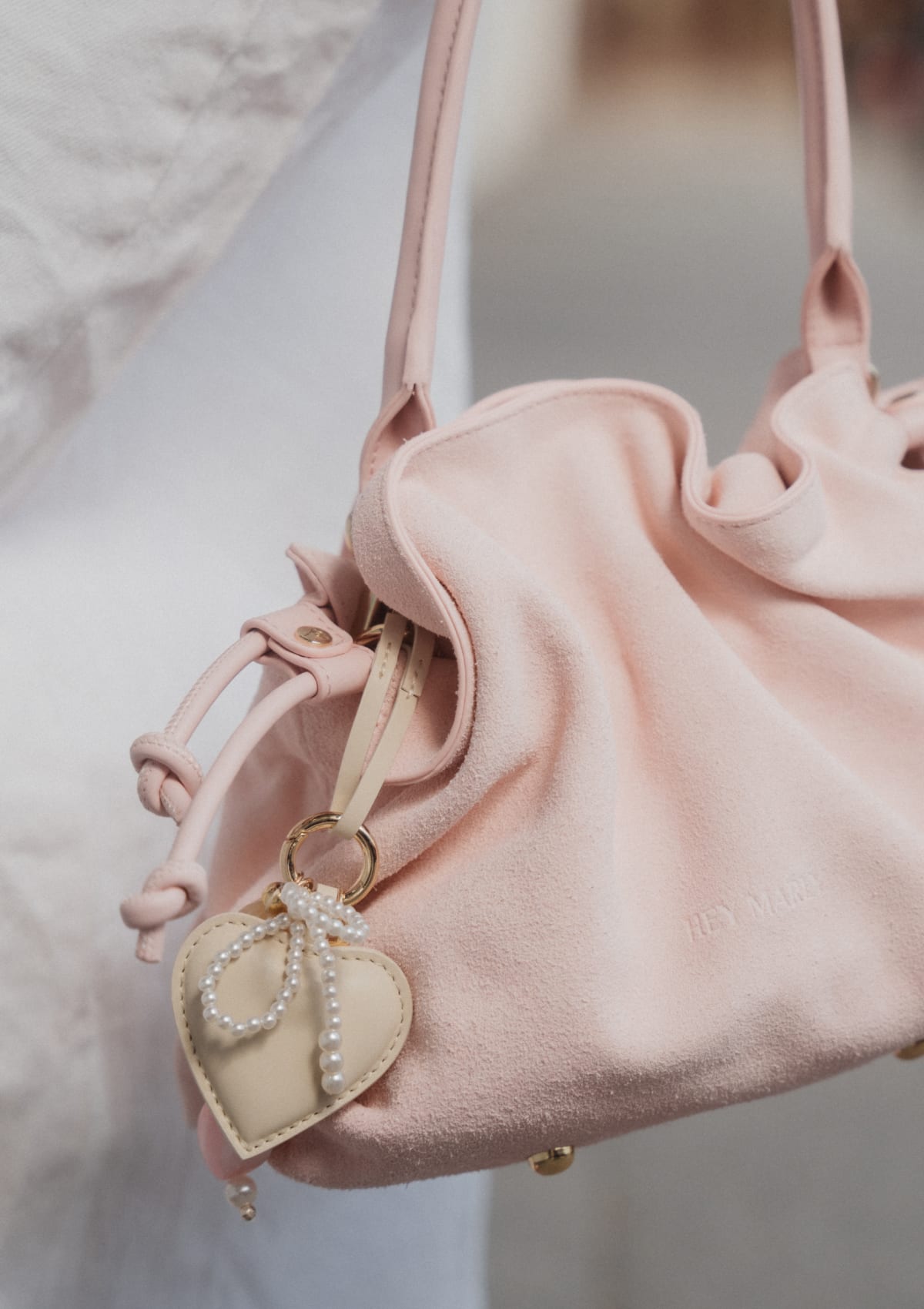 Tragebild mit Model auf neutralem Hintergrund des Produktes Heart & Pearls Charm in der Farbe Crema