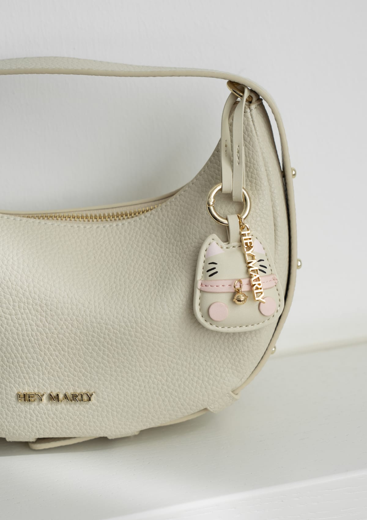 Tragebild mit Model auf neutralem Hintergrund des Produktes Cat Charm in der Farbe Crema