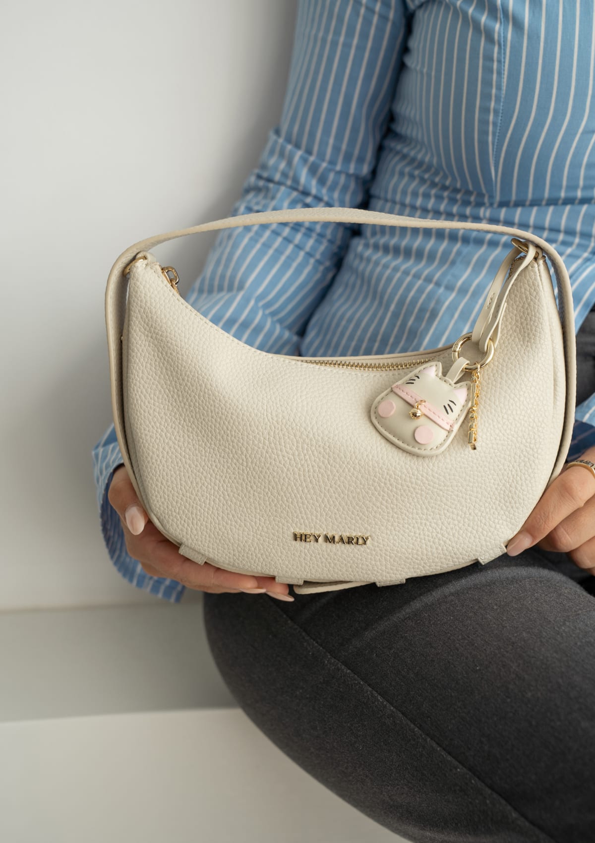 Tragebild mit Model auf neutralem Hintergrund des Produktes Cat Charm in der Farbe Crema