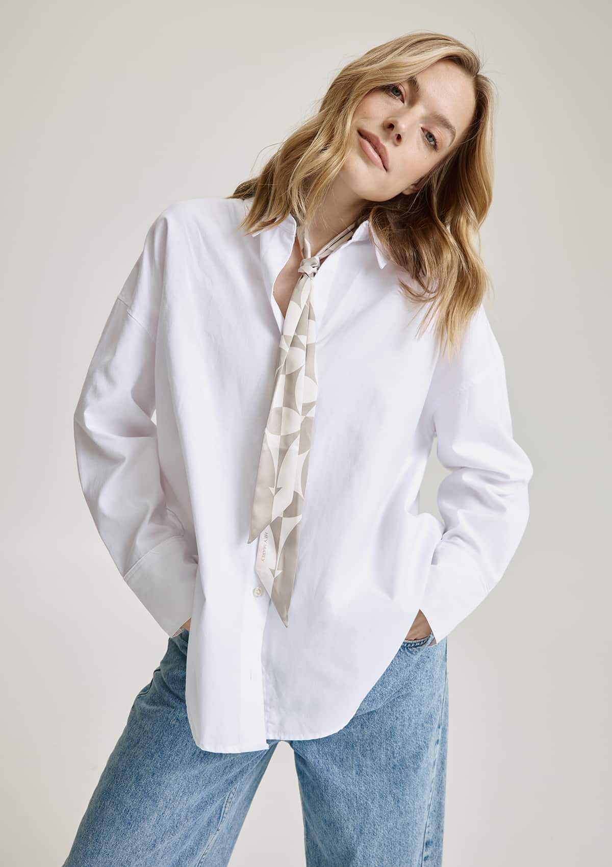 Tragebild mit Model auf neutralem Hintergrund des Produktes Silky Ribbon Logo Print in der Farbe Crema/Greige