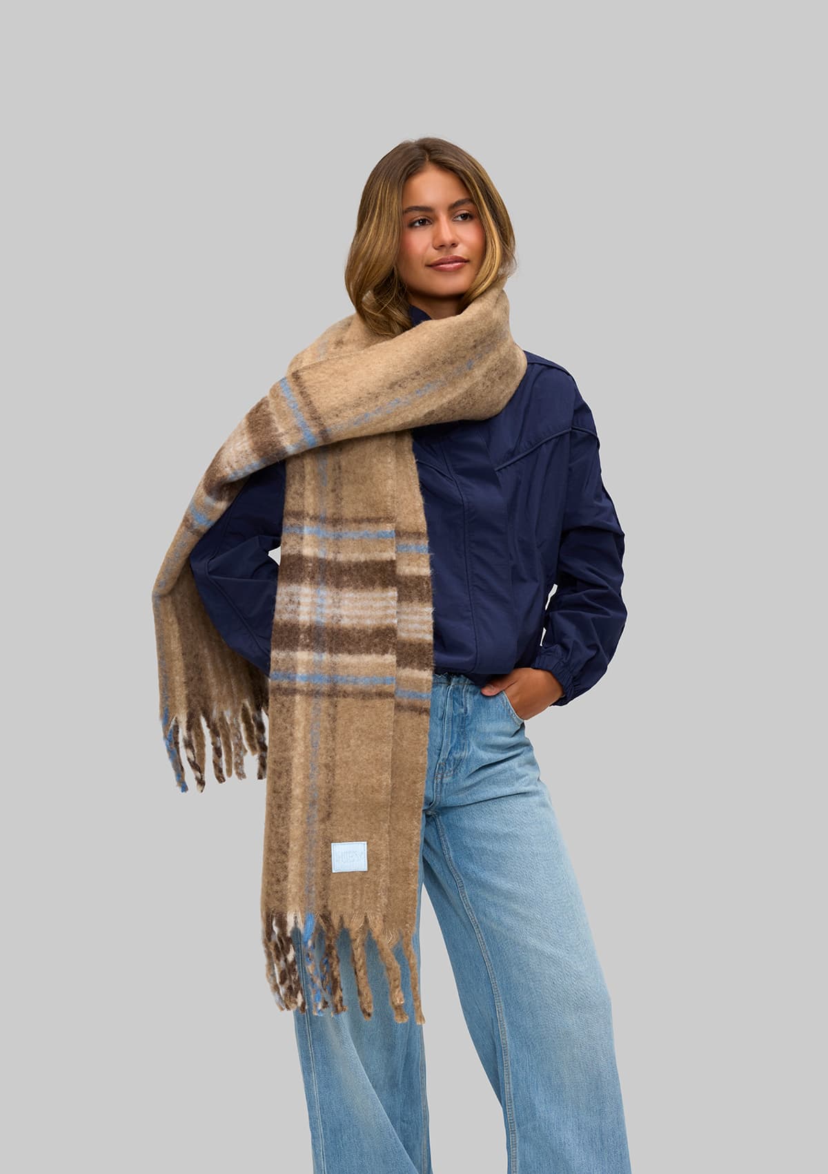 Tragebild mit Model auf neutralem Hintergrund des Produktes Check Scarf in der Farbe Mocha
