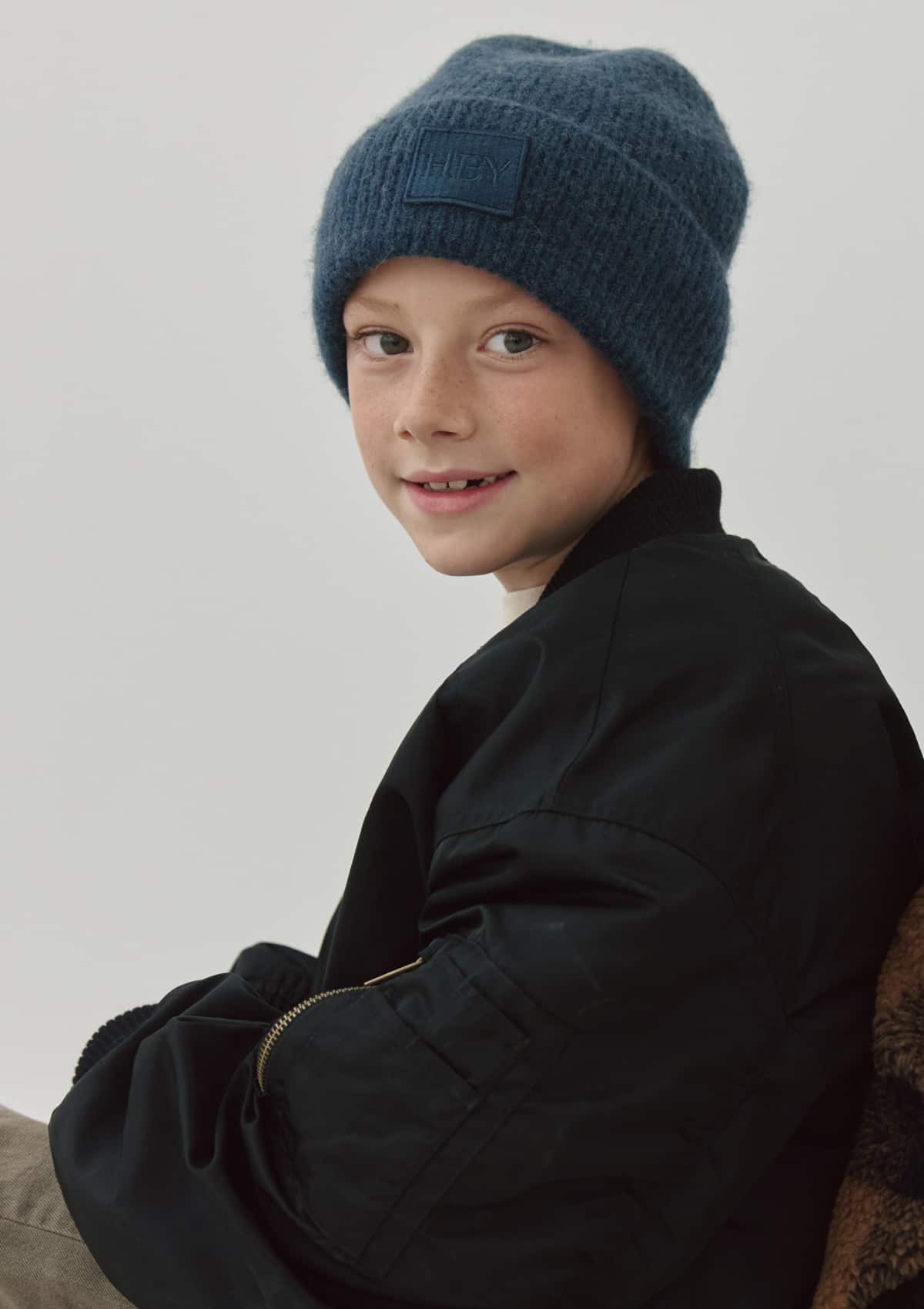 Tragebild mit Model auf neutralem Hintergrund des Produktes Hey Beanie Kids in der Farbe Blue