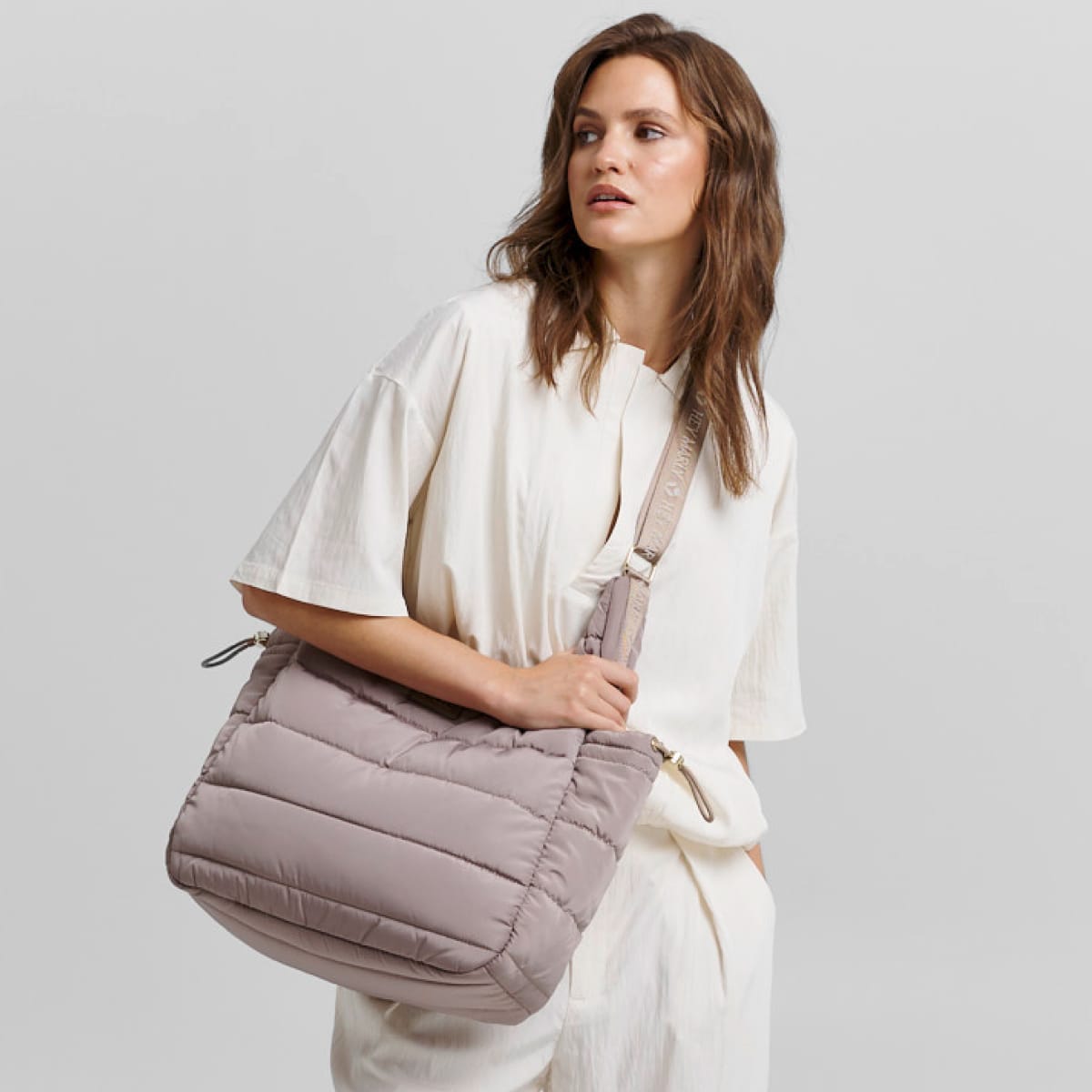 Model mit Puffy Buddy Tasche vor neutralem Hintergrund