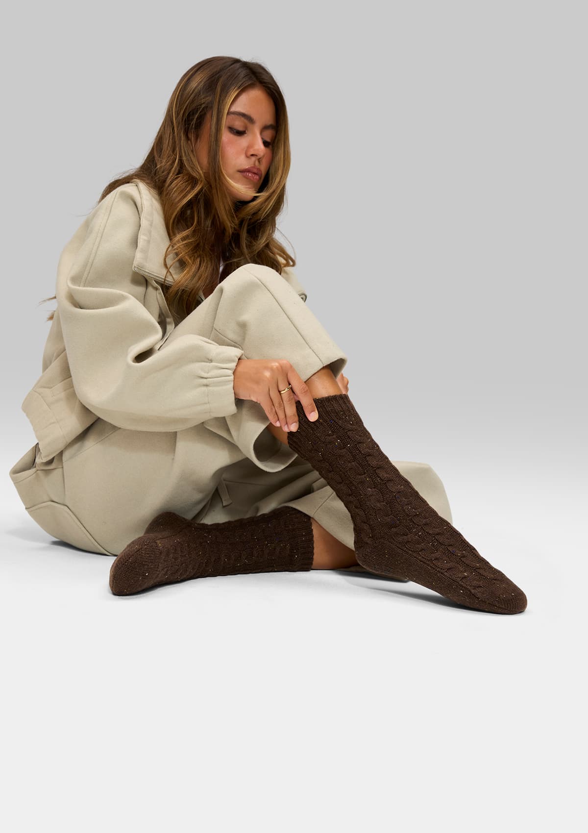 Tragebild mit Model auf neutralem Hintergrund des Produktes Cozy Home Socks in der Farbe Coffee