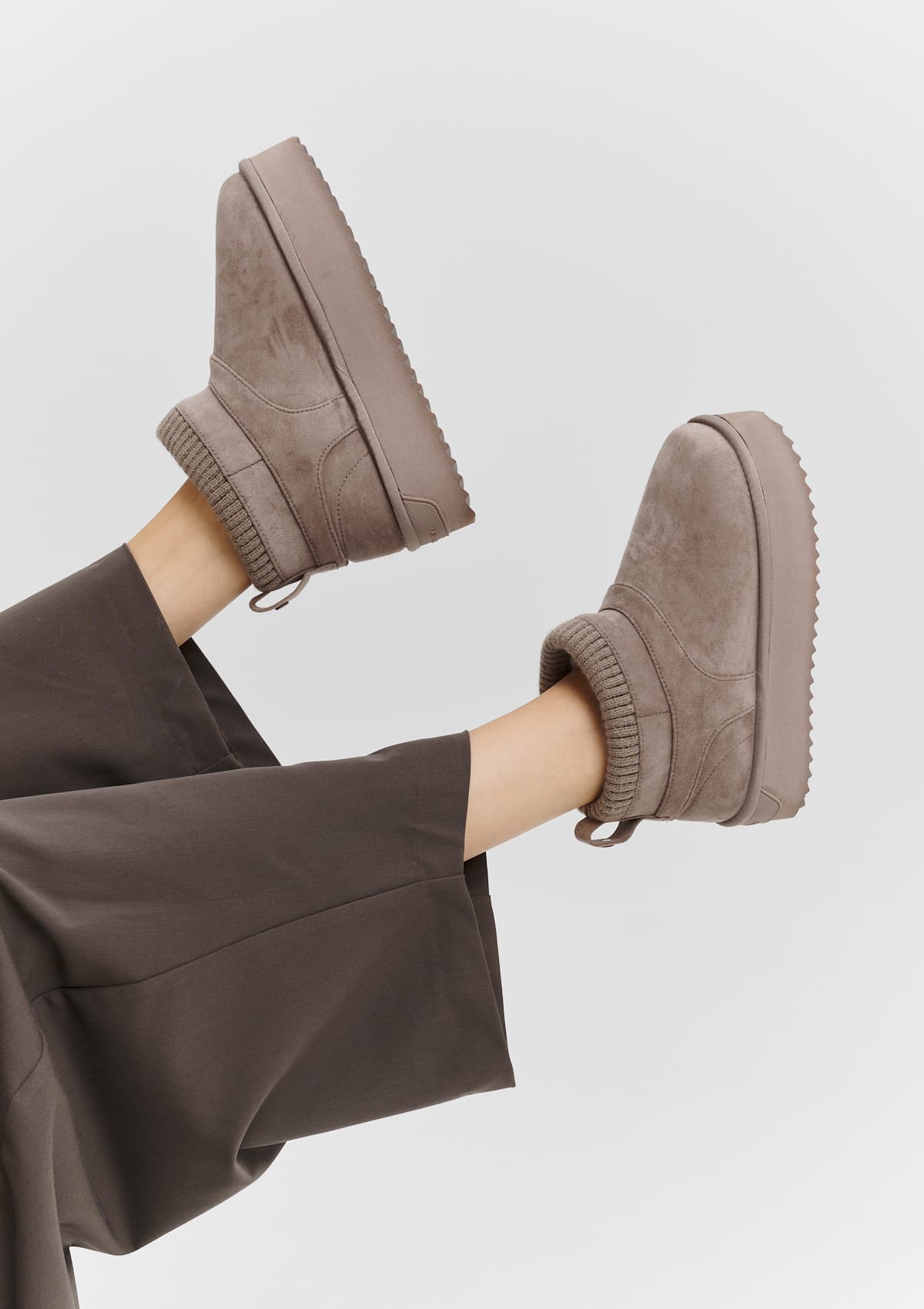 Tragebild mit Model auf neutralem Hintergrund des Produktes Cozy Mid in der Farbe Mocha