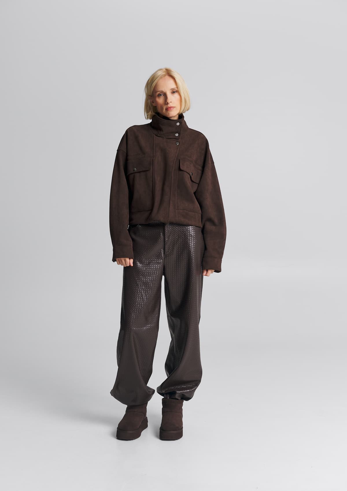 Tragebild mit Model auf neutralem Hintergrund des Produktes Cozy Mid in der Farbe Coffee
