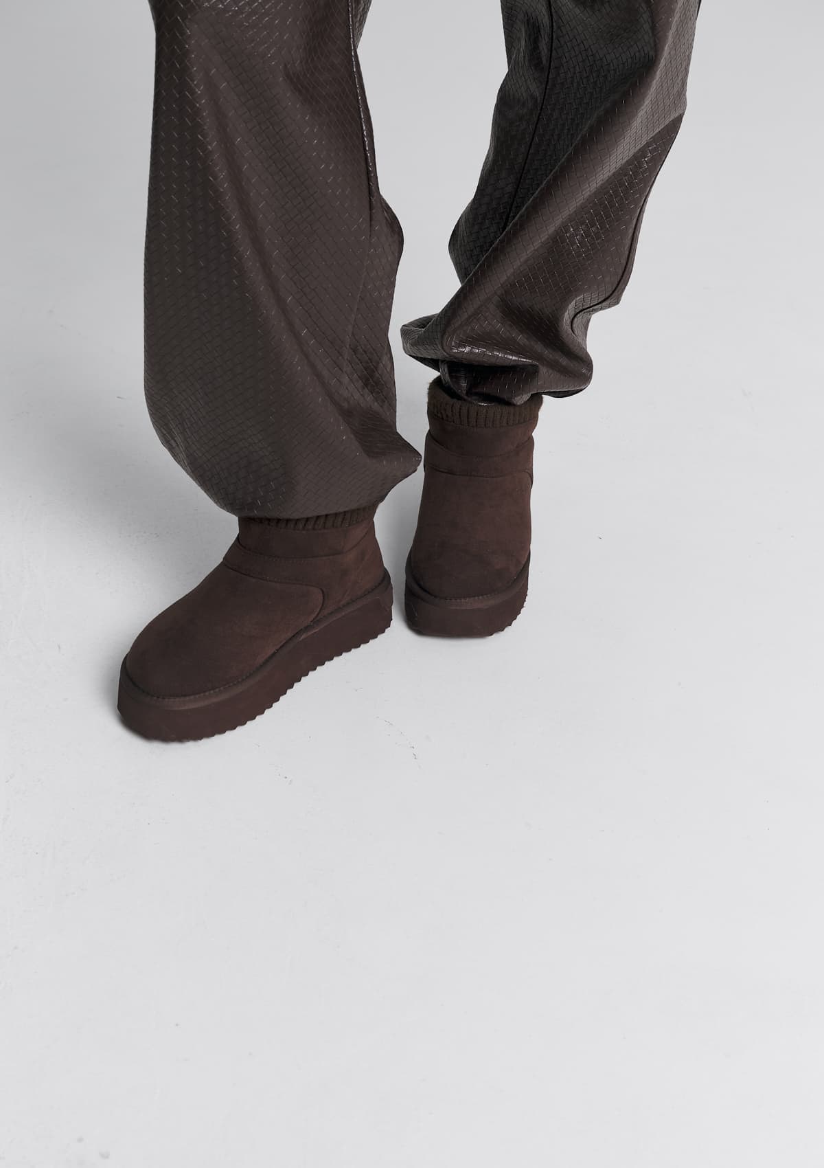 Tragebild mit Model auf neutralem Hintergrund des Produktes Cozy Mid in der Farbe Coffee