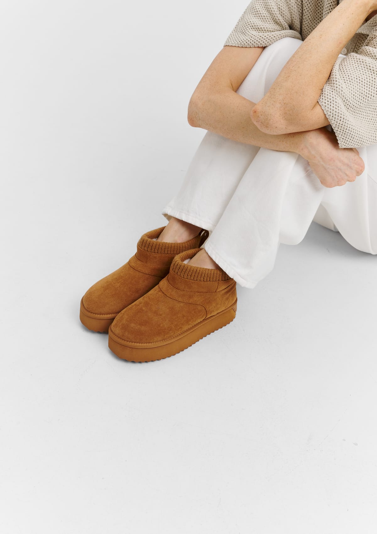 Tragebild mit Model auf neutralem Hintergrund des Produktes Cozy Mid in der Farbe Cognac