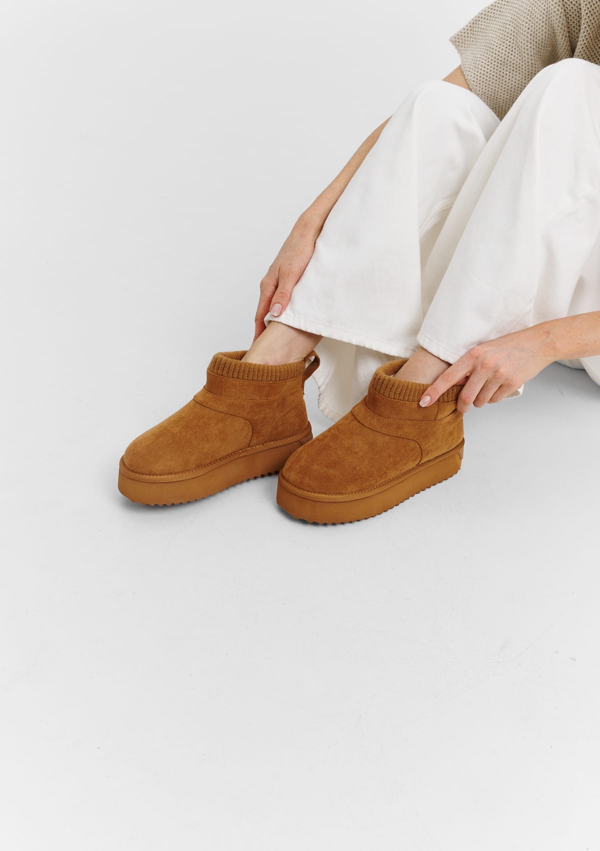 Tragebild mit Model auf neutralem Hintergrund des Produktes Cozy Mid in der Farbe Cognac