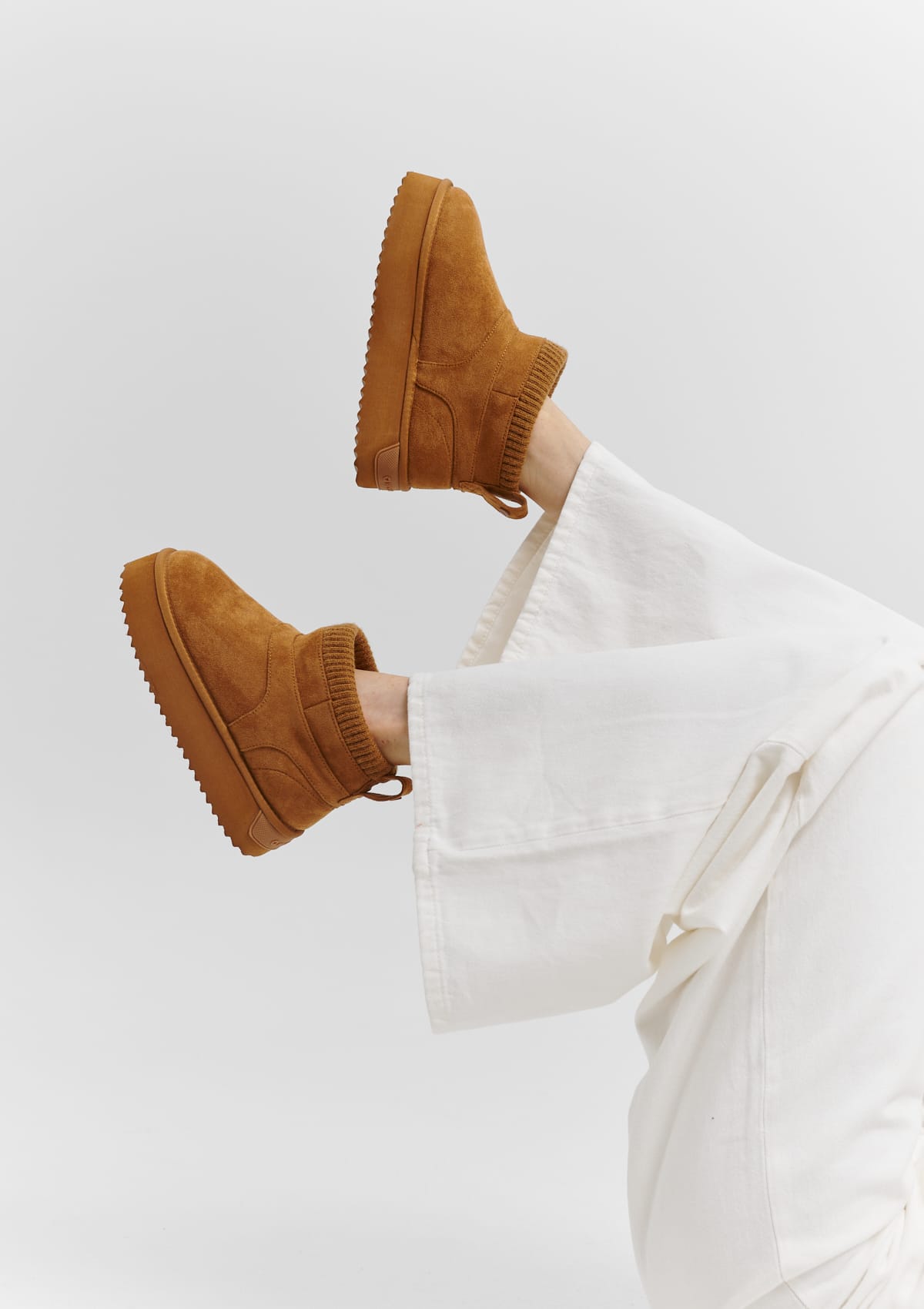 Tragebild mit Model auf neutralem Hintergrund des Produktes Cozy Mid in der Farbe Cognac