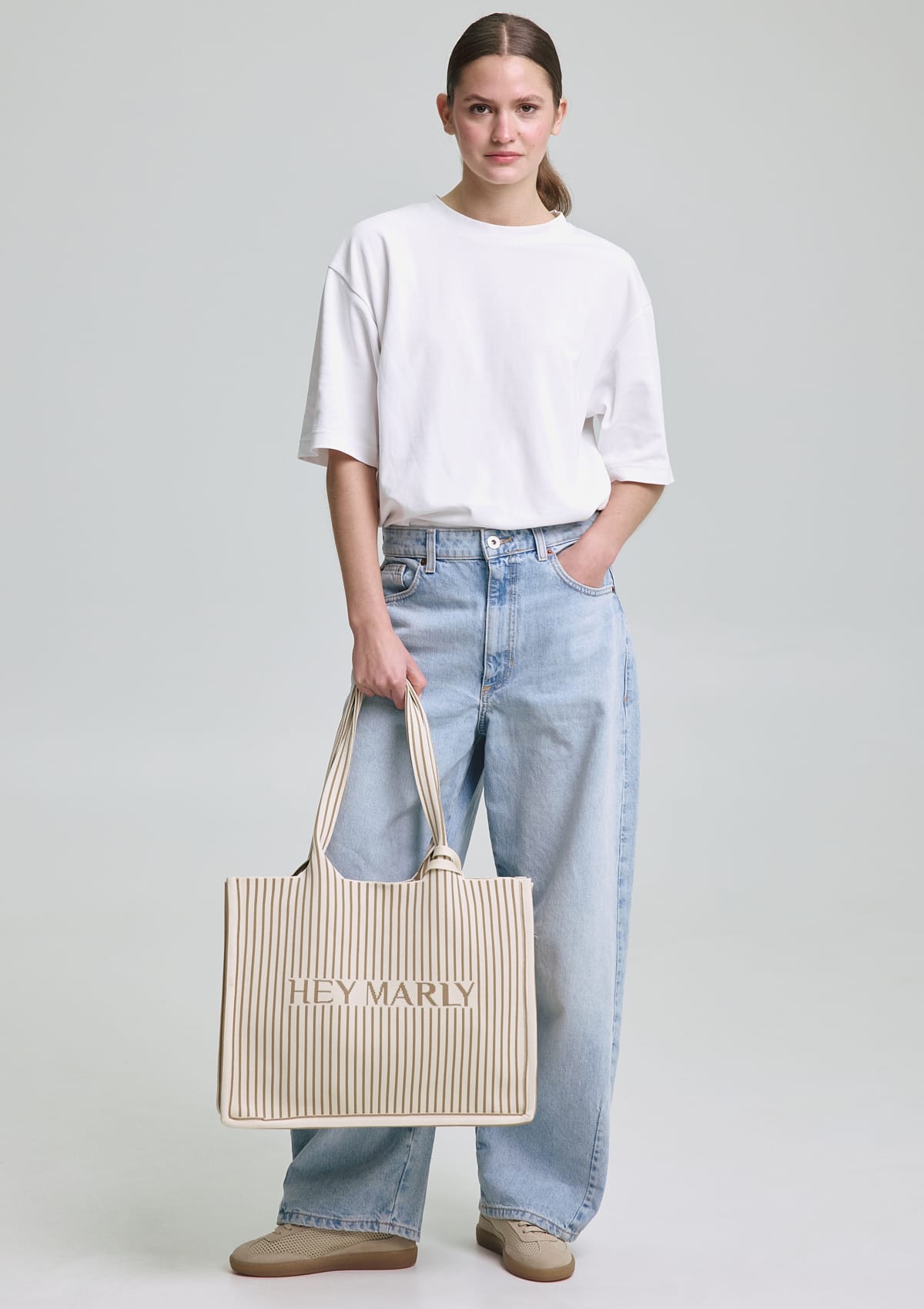 Tragebild mit Model auf neutralem Hintergrund des Produktes Casual Signature Bag in der Farbe Crema-Sand