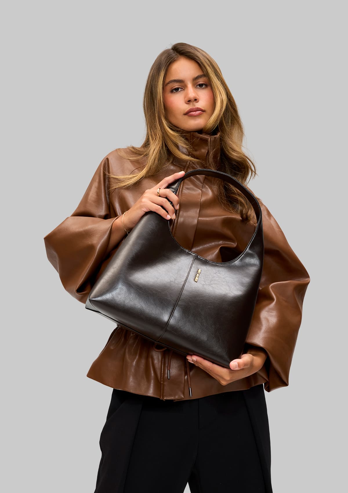 Tragebild mit Model auf neutralem Hintergrund des Produktes Alltime Lover Glossy M in der Farbe Coffee in der Größe M