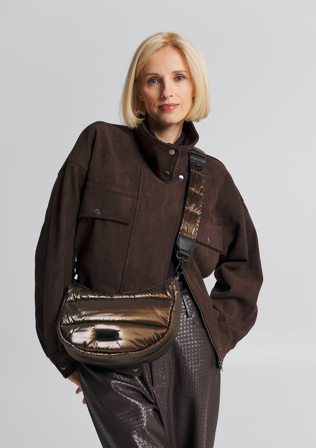 Tragebild mit Model auf neutralem Hintergrund des Produktes Puffy Nylon Strap Blaze in der Farbe Coffee