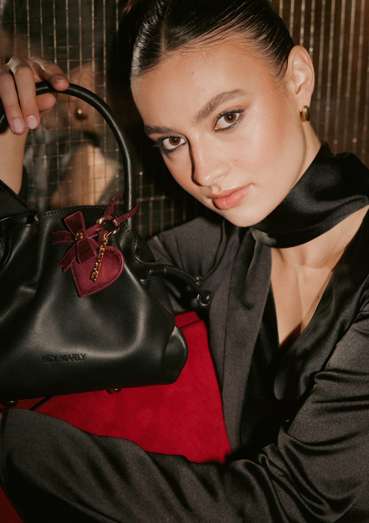 Tragebild mit Model auf neutralem Hintergrund des Produktes Heart & Bow Charm in der Farbe Berry