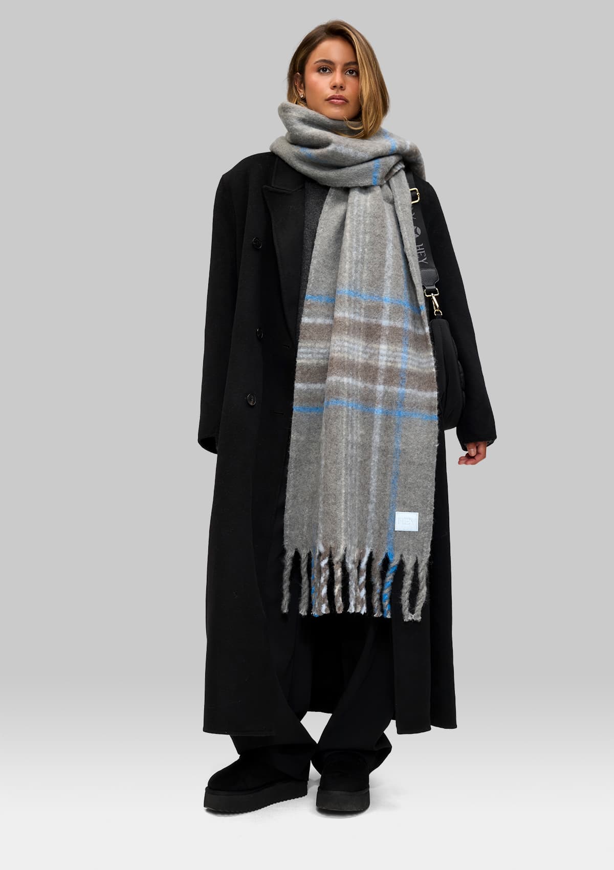 Tragebild mit Model auf neutralem Hintergrund des Produktes Check Scarf in der Farbe Grey