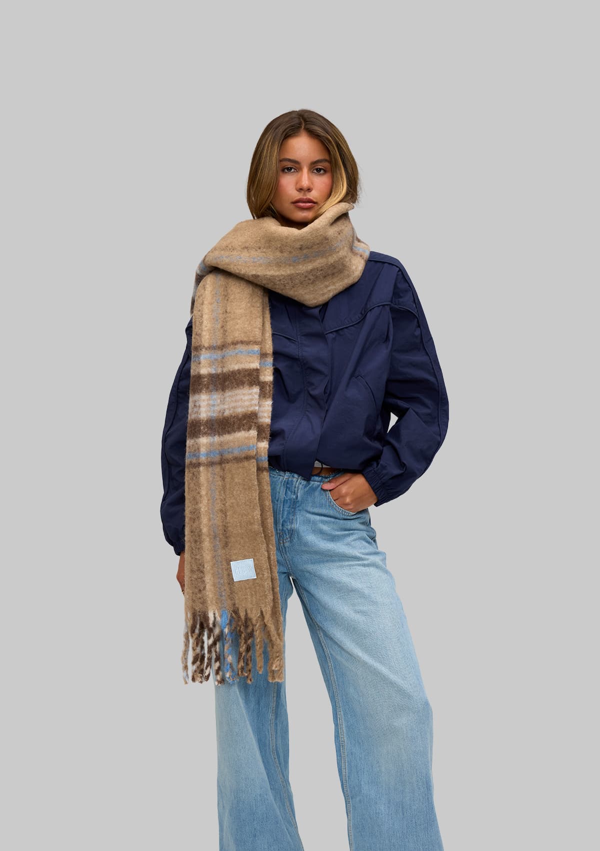 Tragebild mit Model auf neutralem Hintergrund des Produktes Check Scarf in der Farbe Mocha