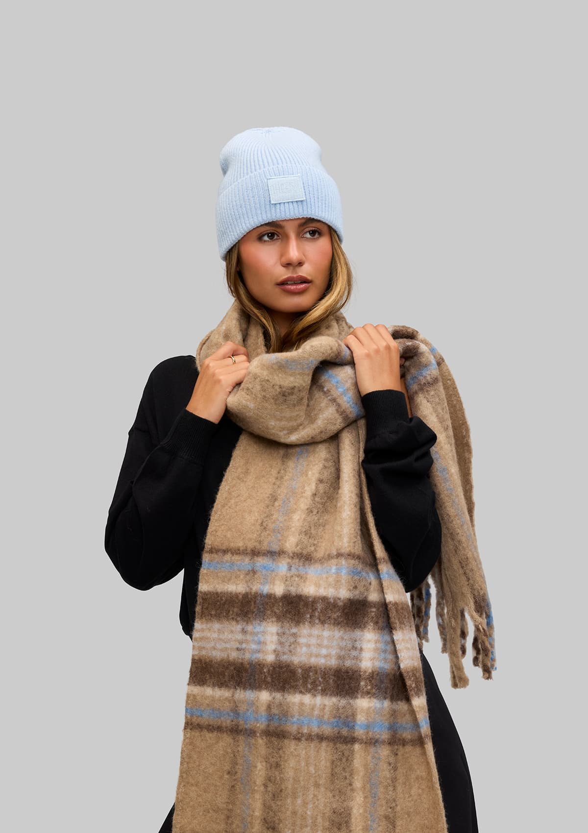 Tragebild mit Model auf neutralem Hintergrund des Produktes Check Scarf in der Farbe Mocha