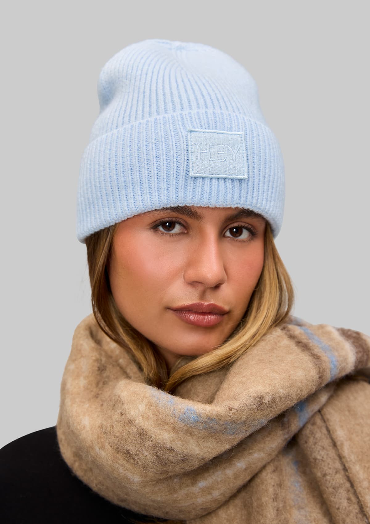 Tragebild mit Model auf neutralem Hintergrund des Produktes Hey Beanie in der Farbe Blue Light